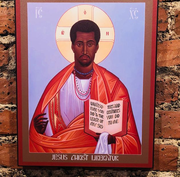 An icon reading &ldquo;Jesus Christ Liberator&rdquo; mounted on a brick wall